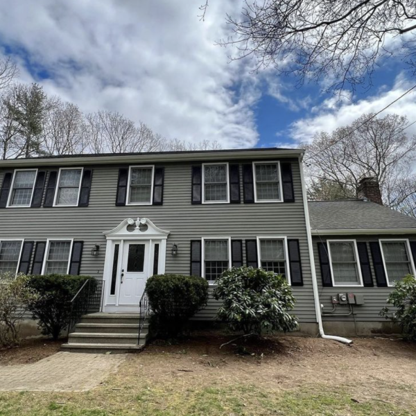 Colonial painted light greenish gray tone. Black shudders, and white trim.